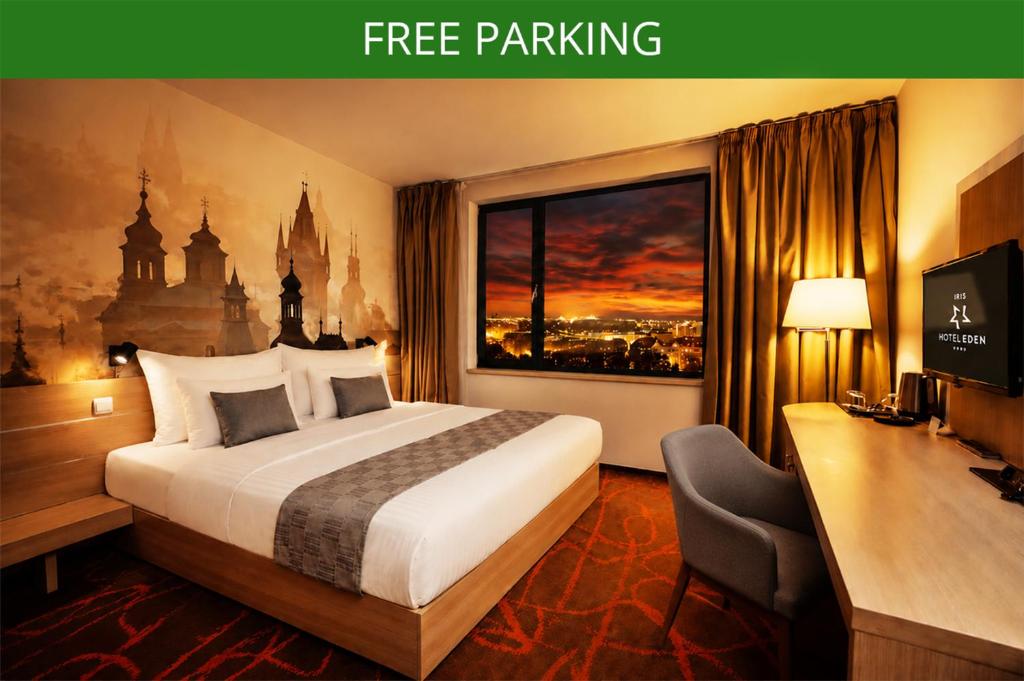 a hotel room with a bed and a desk and a window at Iris Hotel Eden - Czech Leading Hotels in Prague
