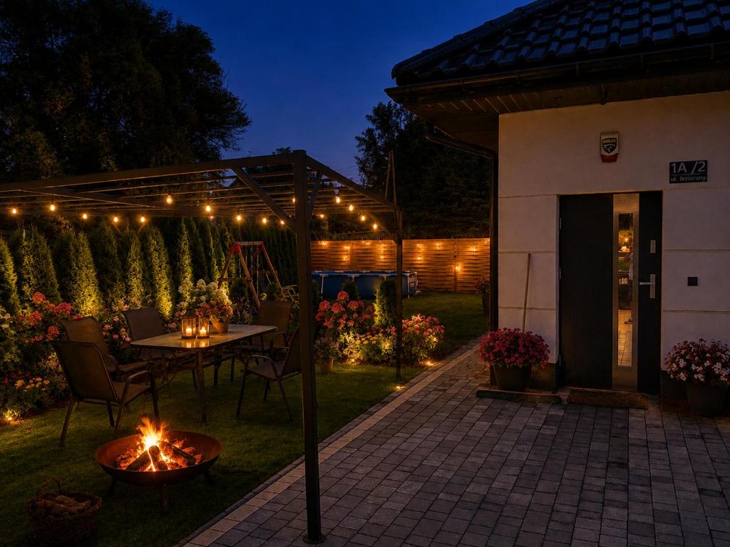 a patio with a table and lights in a yard at Villa Kraków in Krakow