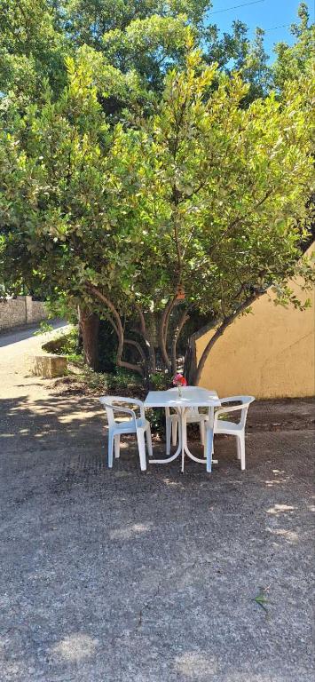 a white table and two chairs under a tree at Mountain Vista Resort in Roústika