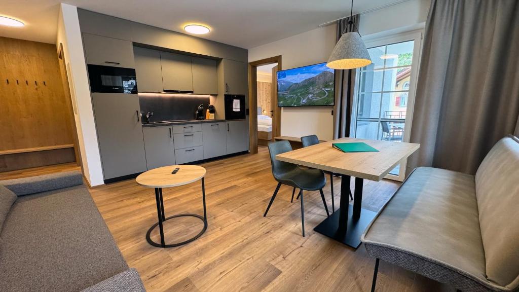 a living room with a table and a kitchen at Marktplatz Apartments Lofer in Lofer