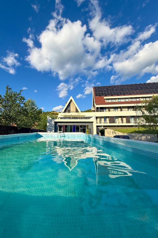a swimming pool with a building in the background at Altus Hotel & Spa in Praid