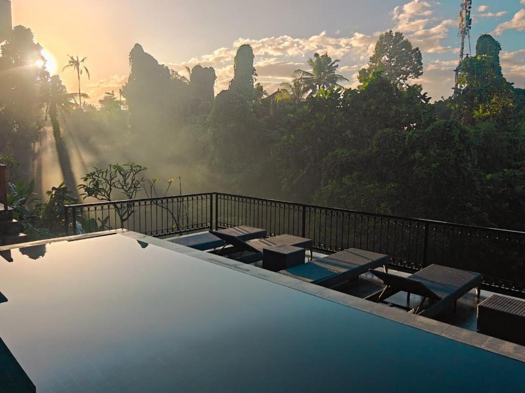 a swimming pool with a view of the jungle at Nawang Sakti in Ubud
