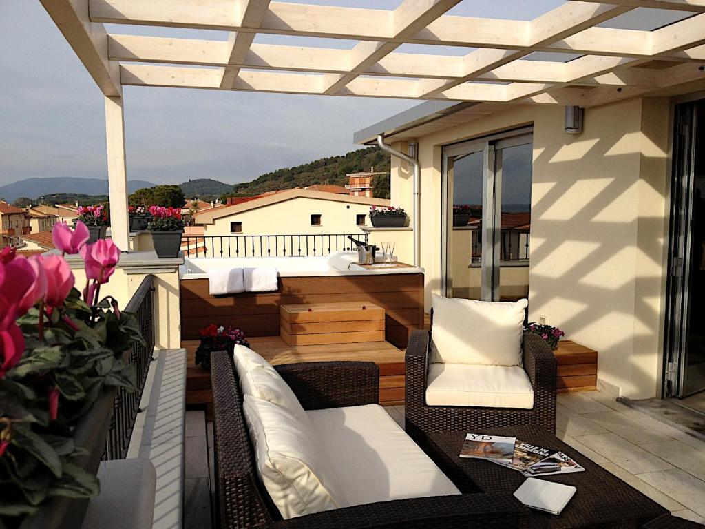 d'un balcon avec une baignoire, une table et des chaises. dans l'établissement Hotel C'era Una Volta, à Castiglione della Pescaia