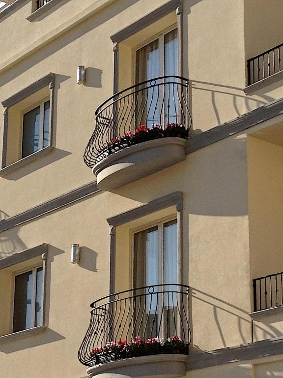a building with balconies and flower boxes on it at Hotel C'era Una Volta in Castiglione della Pescaia