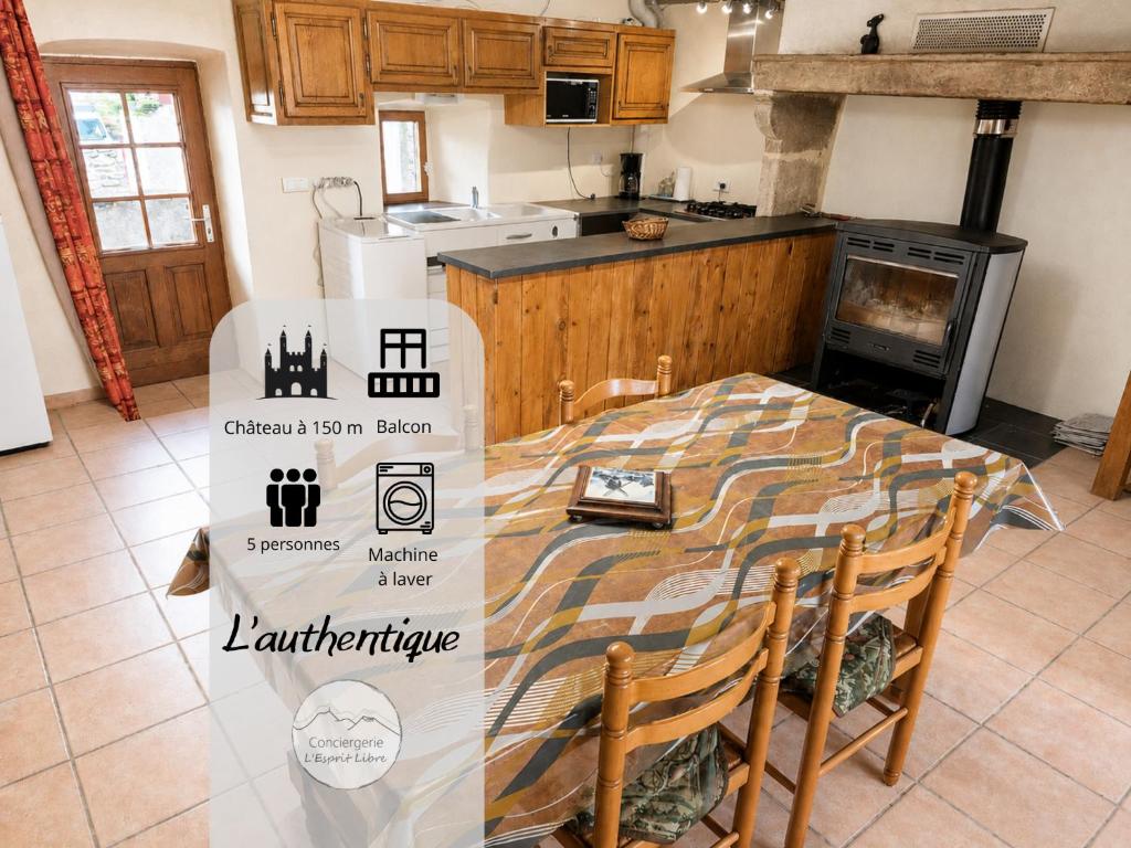 a kitchen with a table with chairs and a stove at L'Authentique - 5 Voyageurs - Château à 150m in Villeneuve