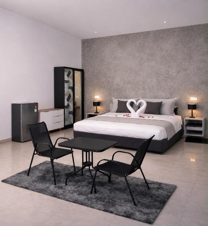 a bedroom with a bed and a table and chairs at Sea Sky Dreams in Kuta Lombok