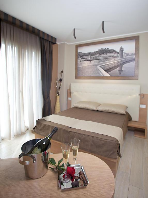 a bedroom with a bed and a table with wine glasses at Hotel C'era Una Volta in Castiglione della Pescaia