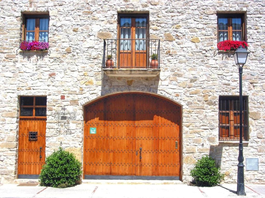 a stone building with a wooden gate and windows at El Clos 2 in Conesa
