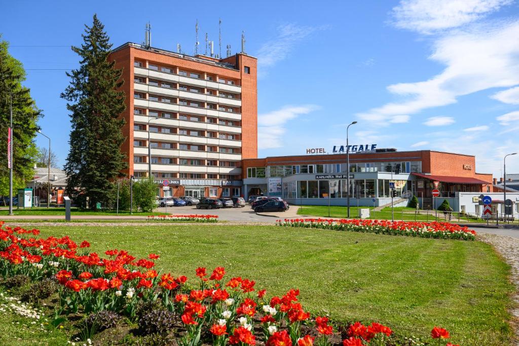 a large building with a lot of flowers in front of it at Latgale in Rēzekne