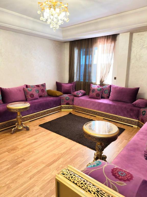 a living room with purple couches and a table at super appartement centre avec parking in Tangier