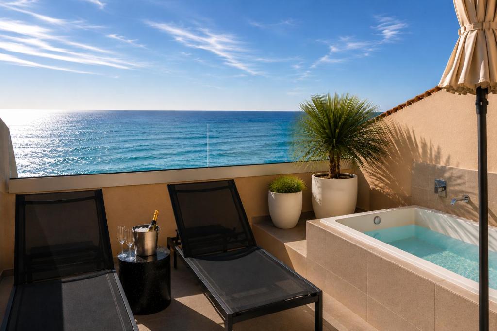a balcony with a bath tub and the ocean at AQUA Hotel Promenade & Spa 4Sup in Pineda de Mar