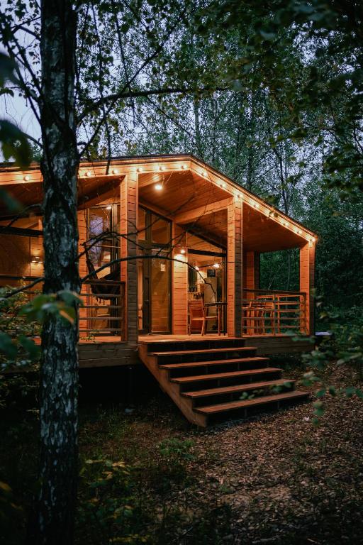 a log cabin in the woods with a tree at УЛІС Віняви in Derevach