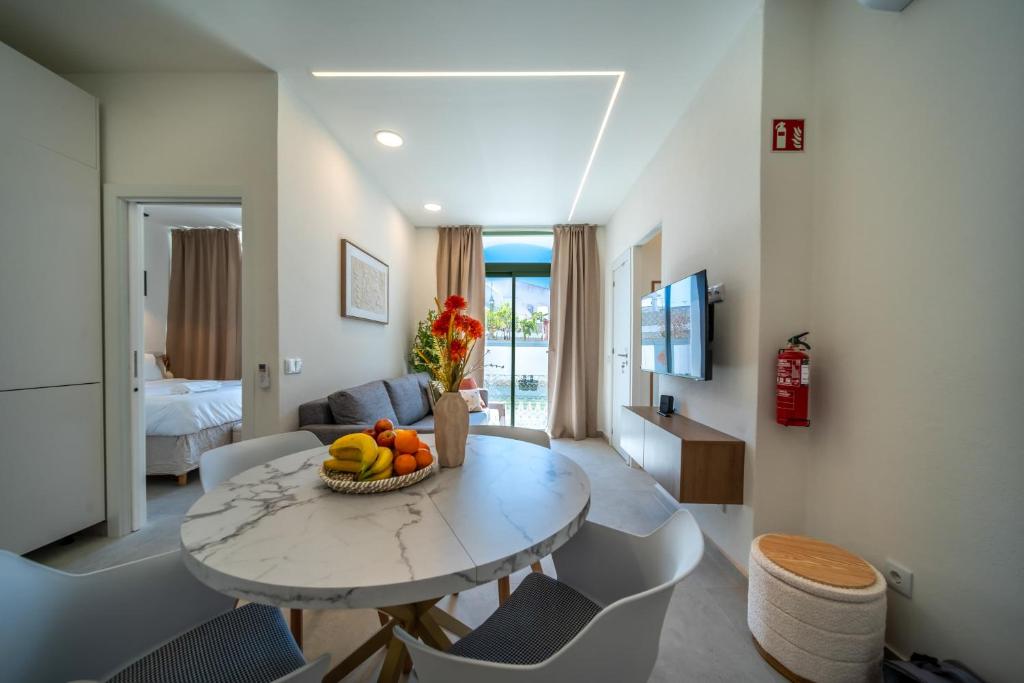 a living room with a table with a bowl of fruit on it at The Simon Residences - Marina Escape in Olhão