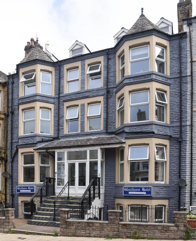 a large blue house with stairs in front of it at The Bay by Guestz in Morecambe