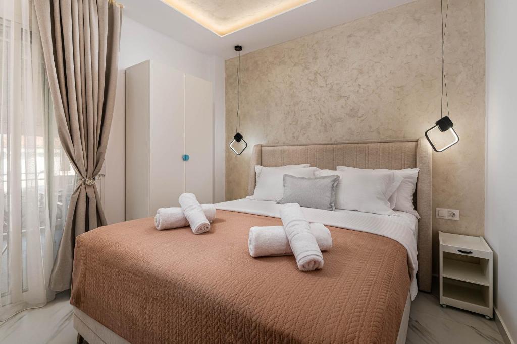 a bedroom with a large bed with towels on it at Kreka Apartments in Pefkochori