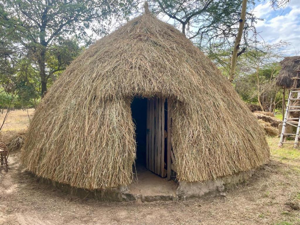 a small thatched hut with a door in it at Akamba Traditional Grass Hut in Emali
