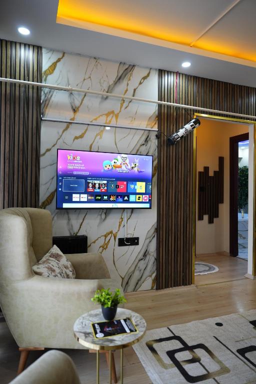 a living room with a tv on a wall at Poli House in Kasaplar