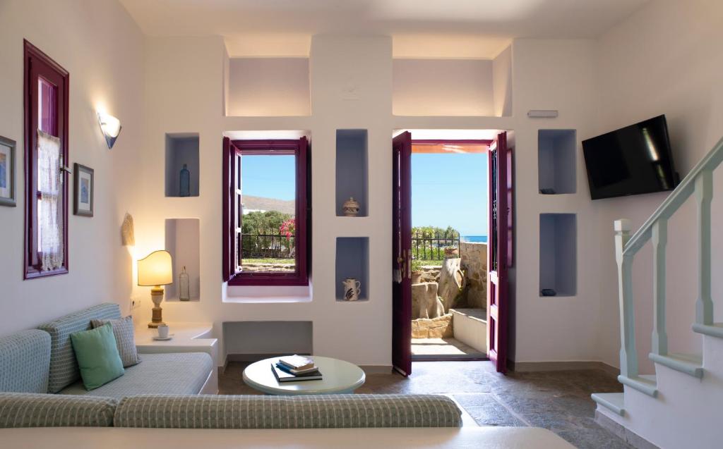 a living room with a couch and two windows at Nefeli Hotel Leros in Agia Marina
