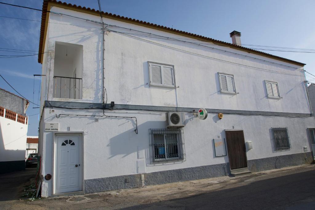 a white building with a door and a window at House Proença in Ladoeiro