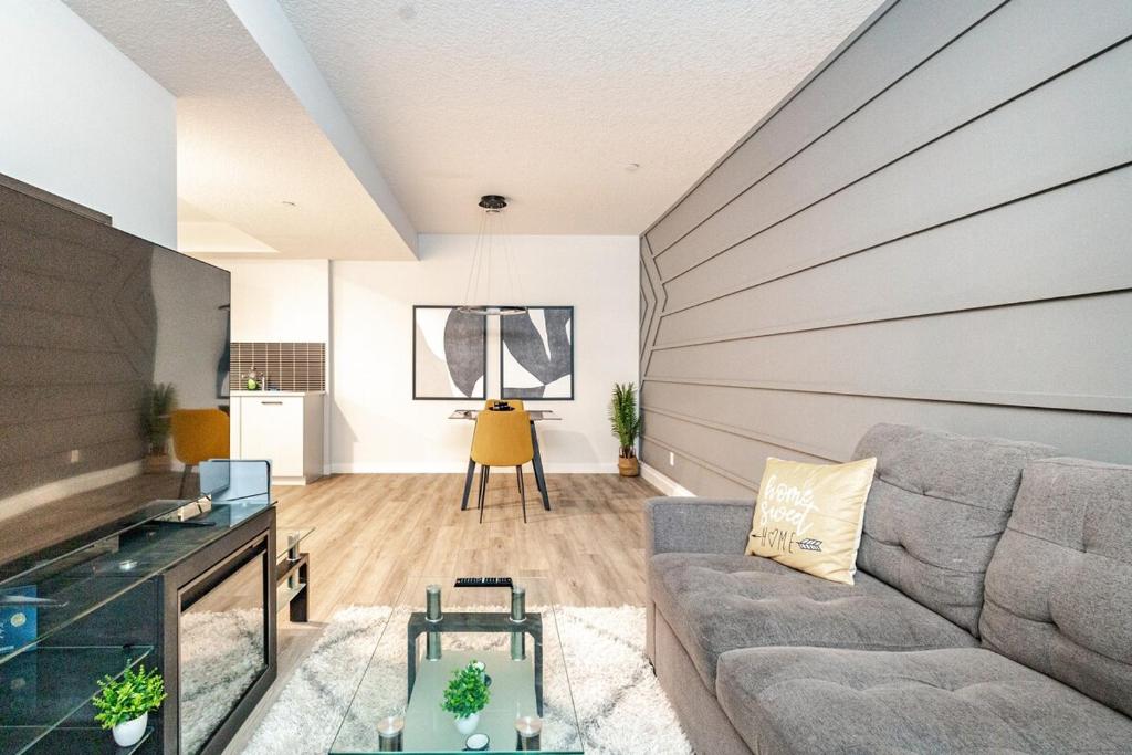 a living room with a couch and a table at Hotchlair Private Suite with Kitchen, Dining & Cozy Living Area in Calgary