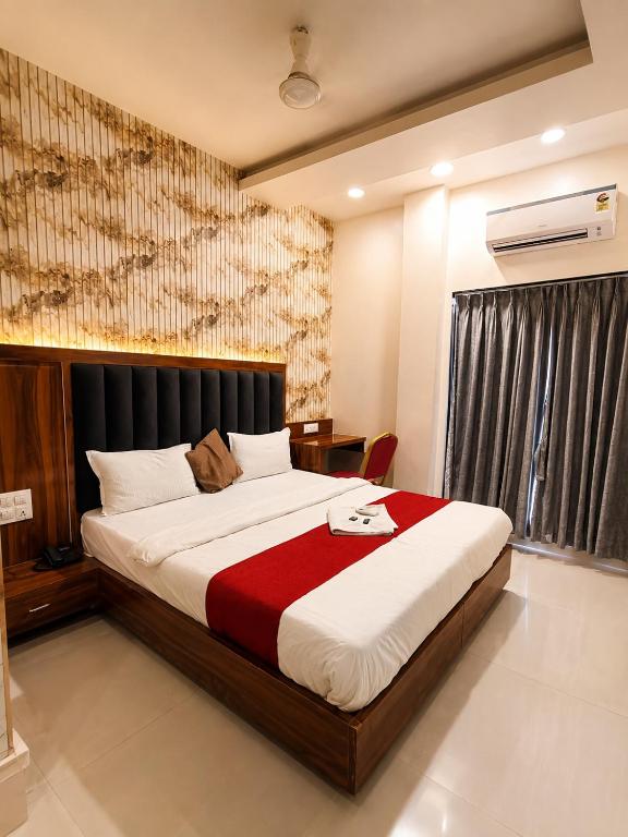 a bedroom with a large bed and a window at Transit Seven Hills Hotel Near Airport Mumbai T2 in Mumbai