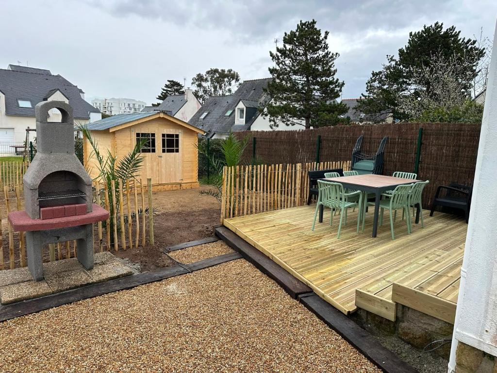 a backyard with a wooden deck with a table and a grill at Ti a mor in Carnac