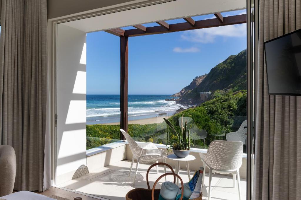 a room with a balcony with a view of the ocean at Secret Sands in Wilderness