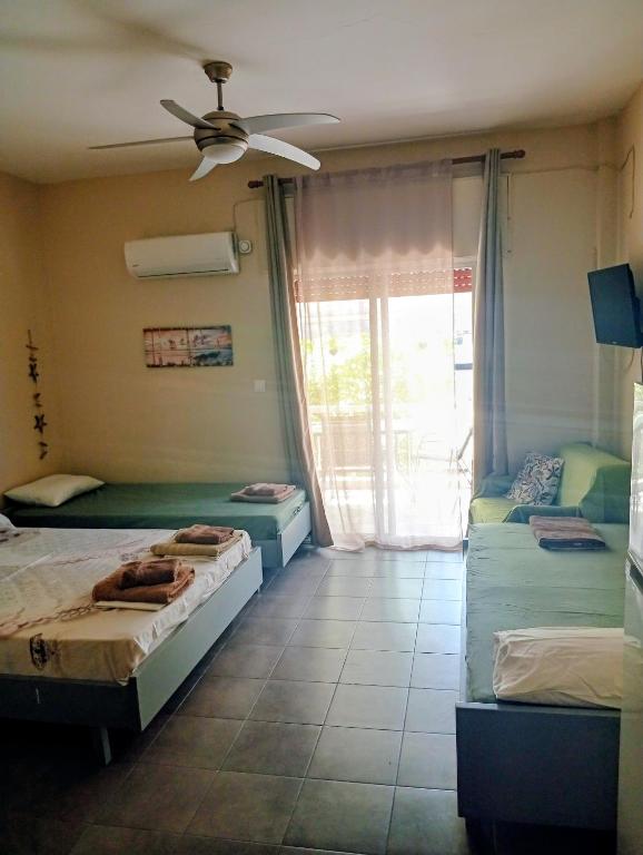 a bedroom with two beds and a ceiling fan at ELENAs in Kallithea Halkidikis