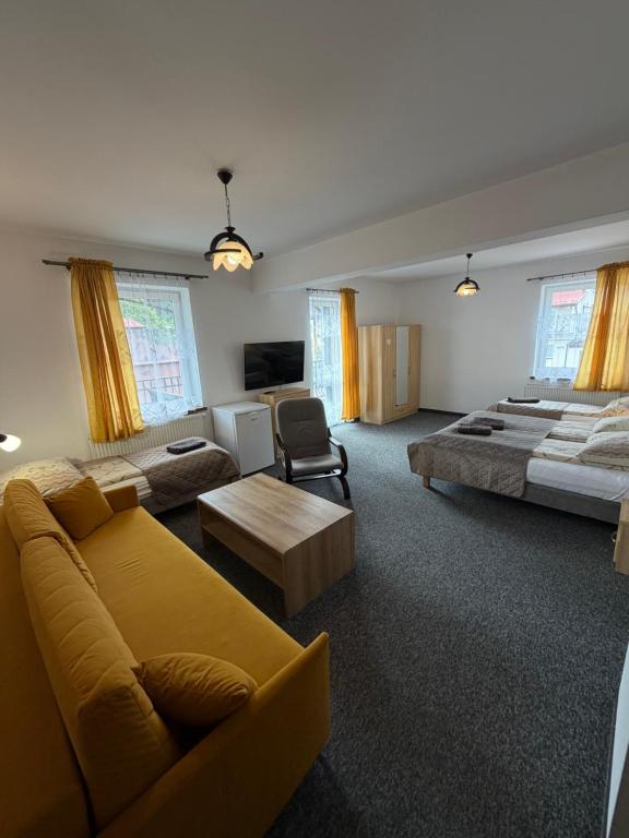 a large living room with a couch and a bed at Centrum Noclegi in Krynica Zdrój