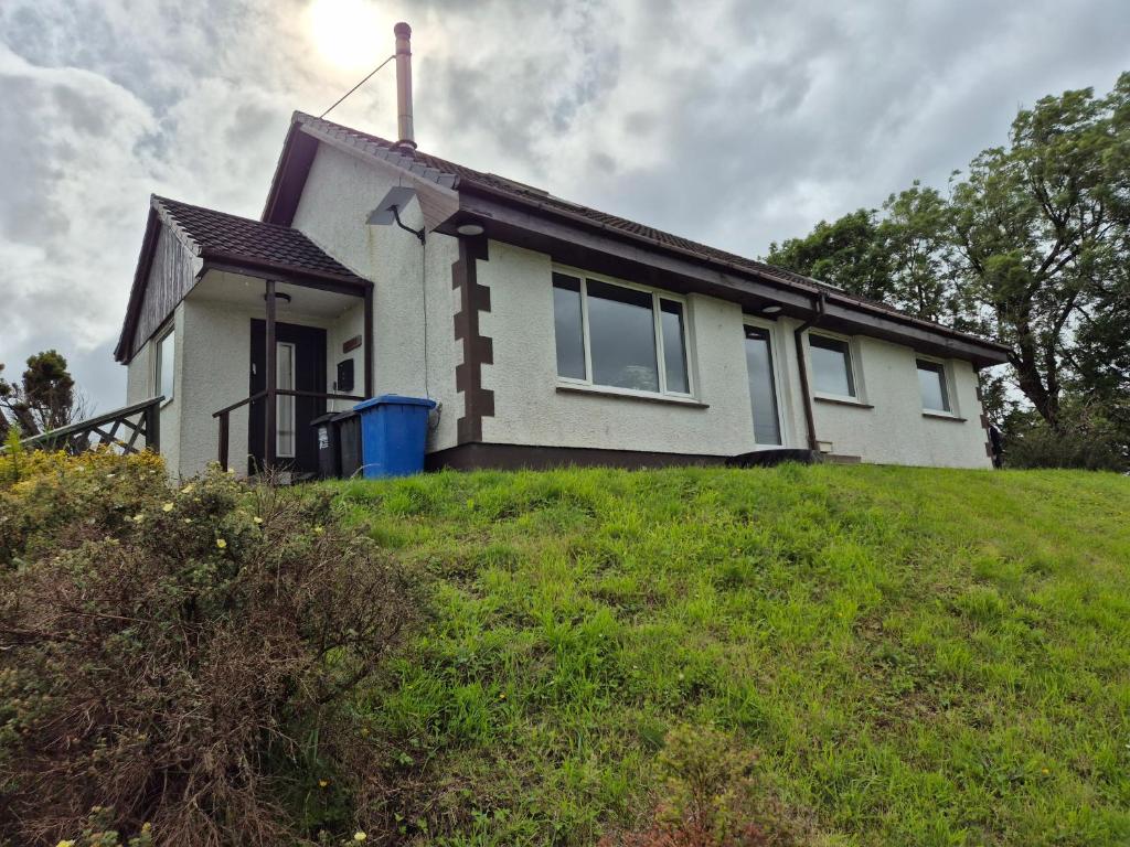 a house on top of a grassy hill at Donrae in Portree