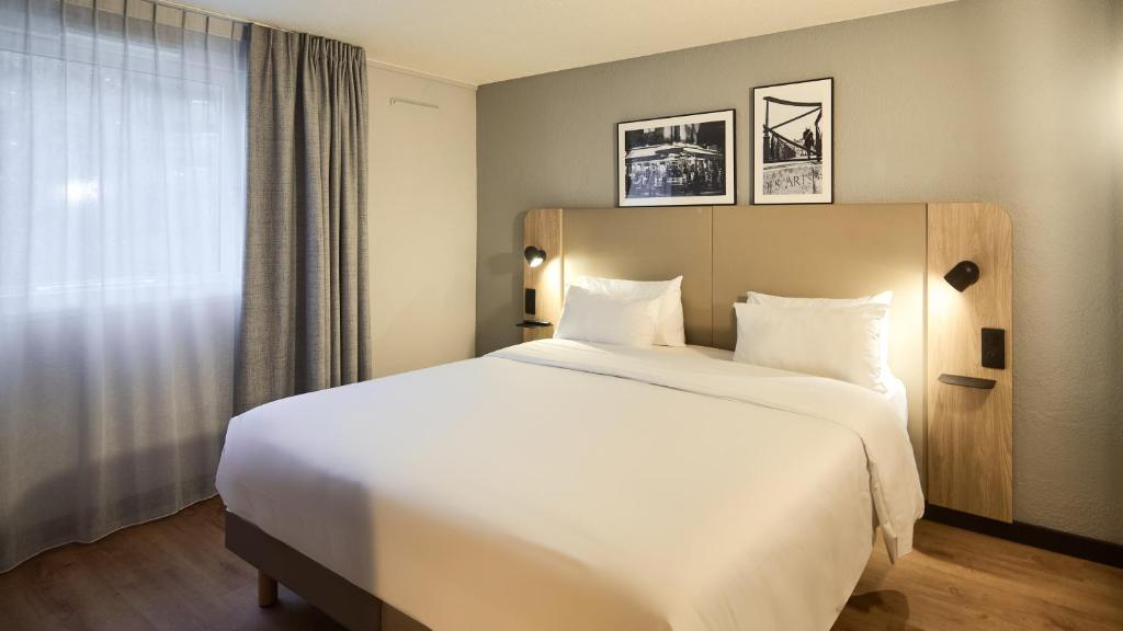 a large white bed in a hotel room at Campanile Lyon Centre - Berges du Rhône in Lyon