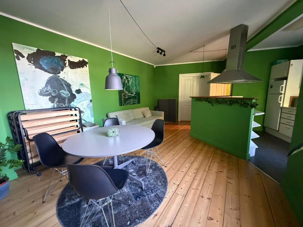 a living room with a table and green walls at Greenbrook Homes - Family 7PPL in Aalborg