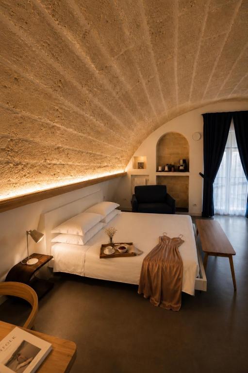 a bedroom with a large bed with a large ceiling at Il Giramondo Suite&Room in Matera