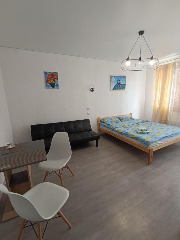 a living room with a bed and a table and chairs at Жилье у моря in Odesa