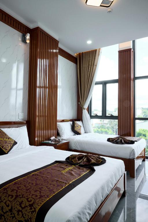 a hotel room with two beds and a window at Phố Núi 2 Hotel in Pleiku