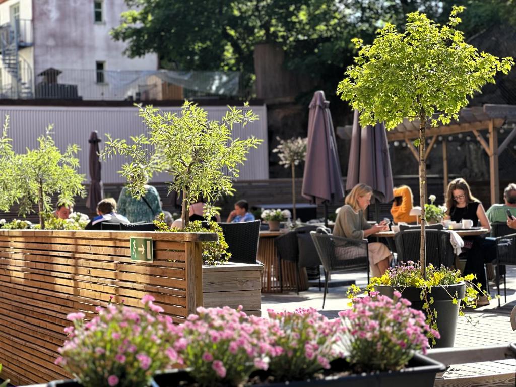 a group of people sitting at tables in a garden at Spar Hotel Majorna in Gothenburg