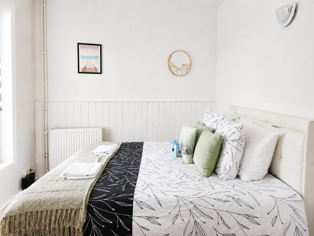a bedroom with a large bed with white and green pillows at Maisonnette en duplex avec Jardin-Babyfoot et Billard in Outreau