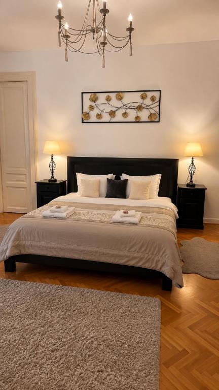 a bedroom with a large bed with a chandelier at Mid Ultra Central Apartments, Self Check In in Oradea