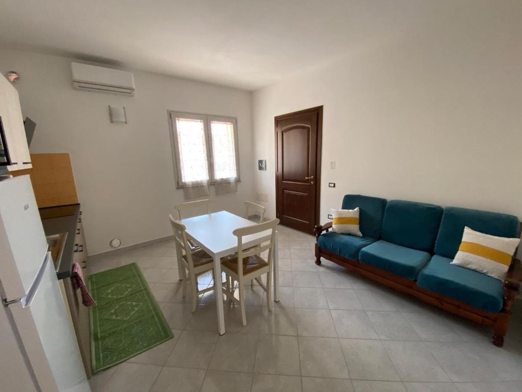 a living room with a blue couch and a table at Ginestra in Galtellì