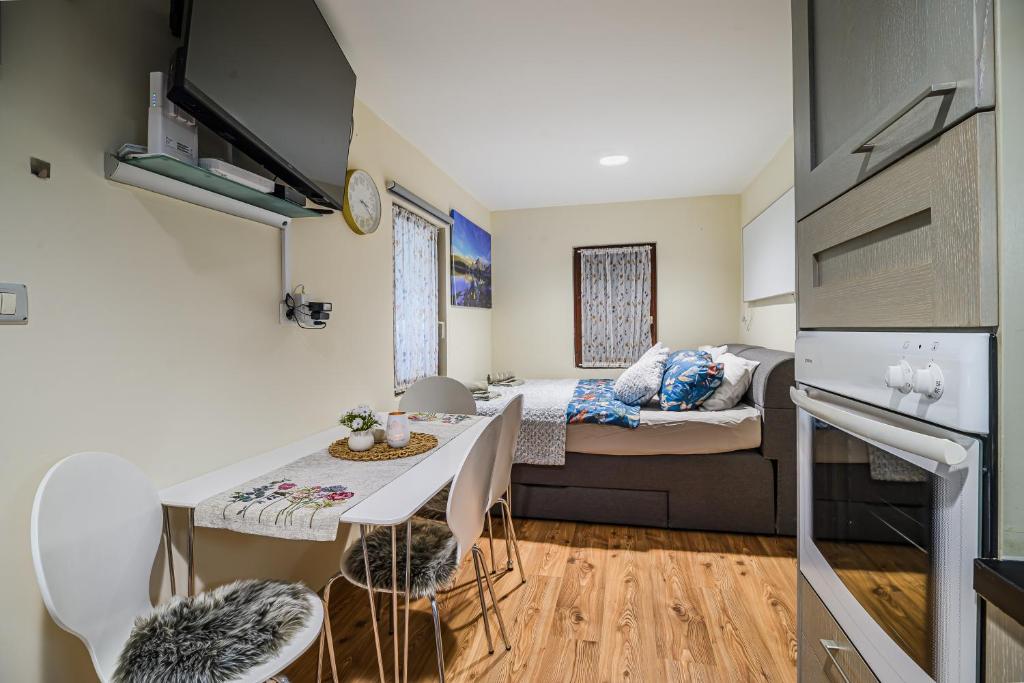 a small room with a bed and a table and chairs at Urška's Premium House Terme Čatež in Brežice