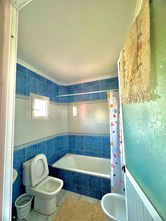 a blue tiled bathroom with a toilet and a bath tub at اقامة الابرار in Oued Laou
