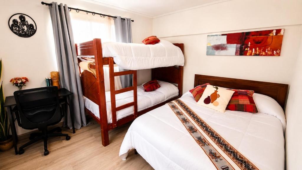 a bedroom with two bunk beds and a desk at Milagro Andino in Arica