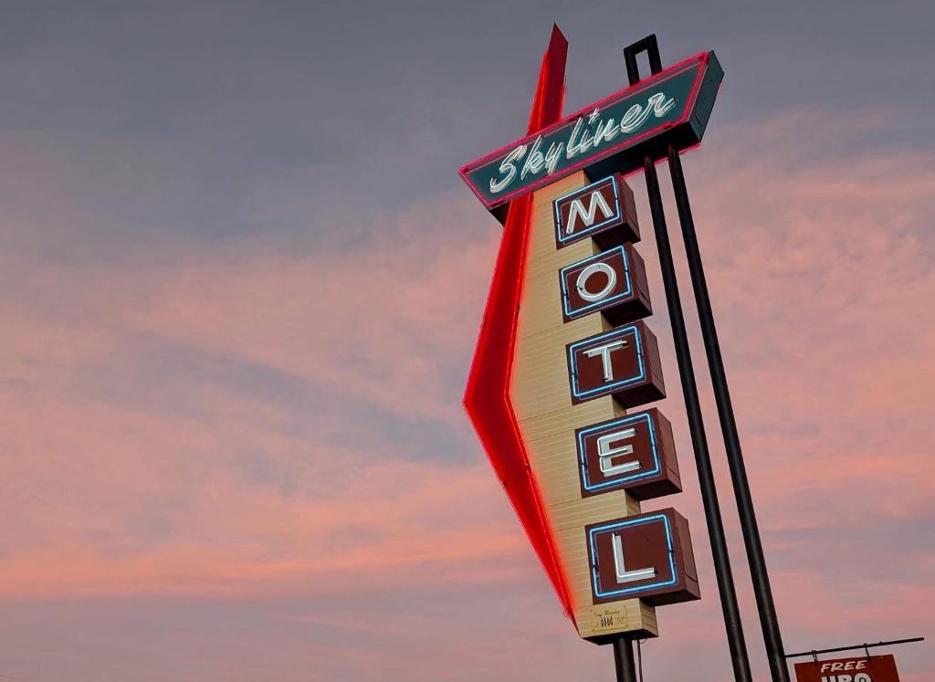 a sign for a motel with a cloudy sky in the background at Skyliner Motel in Stroud