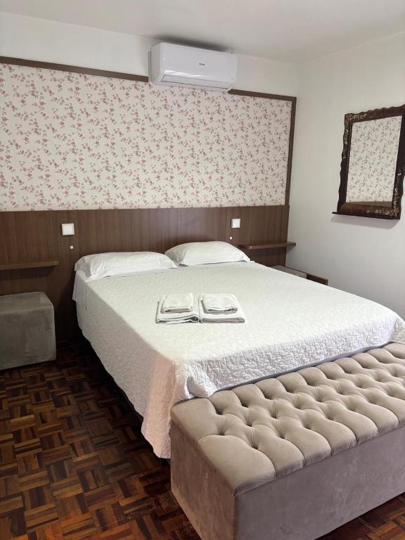 a bedroom with a large bed with two plates on it at Hospedaria Gãstehaus Enzian in Treze Tílias