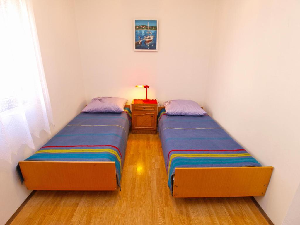 2 łóżka pojedyncze w pokoju ze stolikiem. w obiekcie Apartments Biskupije 940 w Medulinie