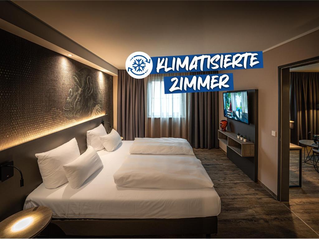 a hotel room with two beds and a television at LOGINN Hotel Stuttgart Zuffenhausen in Korntal-Münchingen