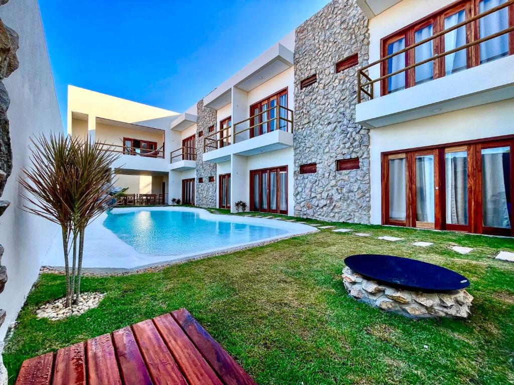 a house with a swimming pool in the yard at Pousada Veleiro Kite Preá in Prea