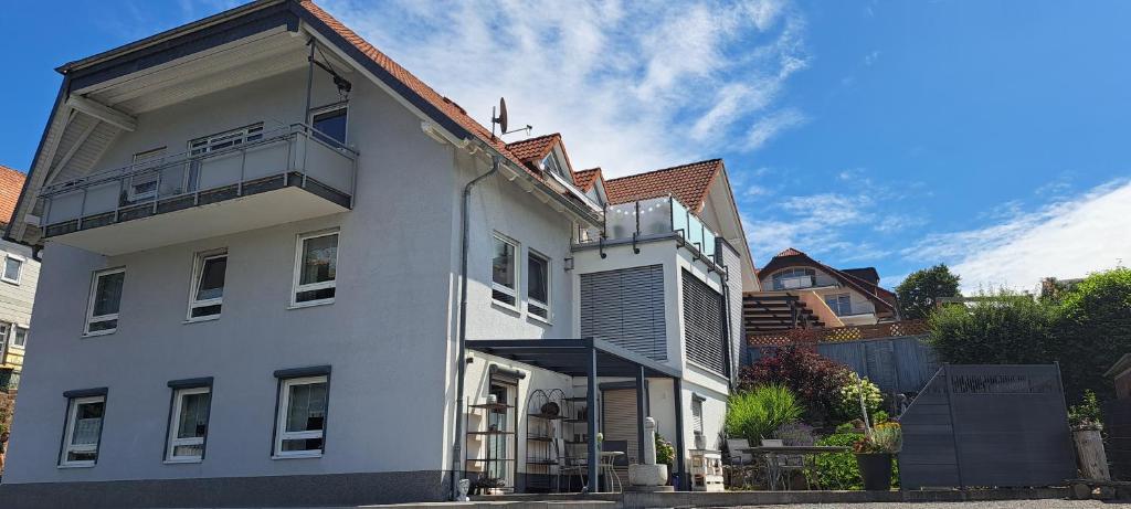 a white building with a brown roof at Ferienwohnung Am Stadttor in Tann