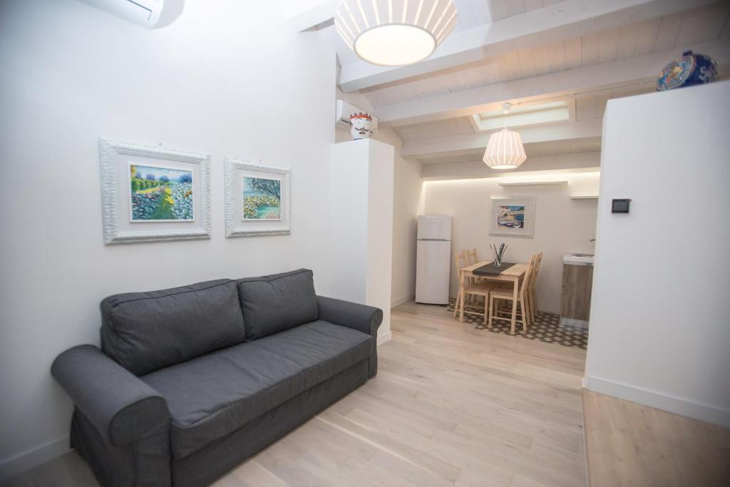 ein Wohnzimmer mit einem Sofa und einer Küche in der Unterkunft Residence Ventimiglia in Gangi