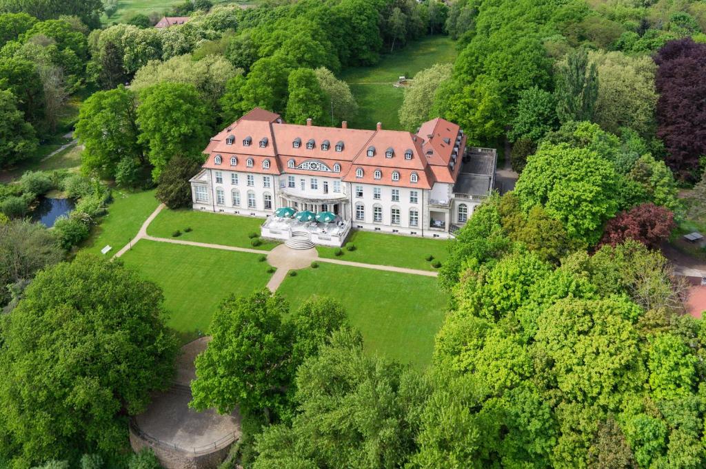 an aerial view of a large house in the forest at Hotel Schloss Storkau in Storkau
